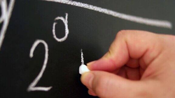手持粉笔在黑板上写下复杂复杂的数学公式