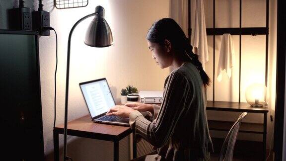 亚裔女性在家庭办公室工作在电脑前工作