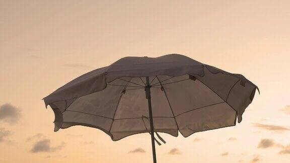 拍摄伞海滩在美丽的日落剪影