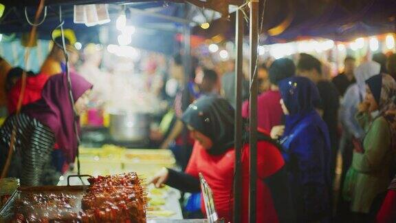 慢镜头拍摄马来西亚金马伦高地的金山夜市上的马来西亚街头小吃