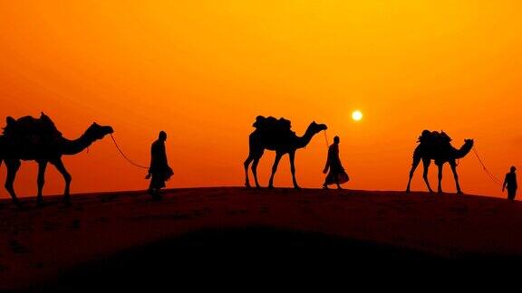 日落时骑骆驼的人和骑骆驼的人印度拉贾斯坦邦贾伊萨默尔夕阳下的塔尔沙漠