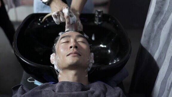 亚洲华人发型师在发廊为顾客洗头