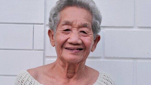 白色墙壁背景上微笑的亚洲老年妇女的肖像肖像老年人退休人生活方式医疗保健和医学概念高级的肖像