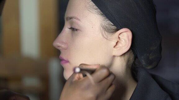 化妆师在模特脸上涂抹粉底