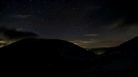 星星和云在冬季群山的夜空中移动梦幻般的天文延时