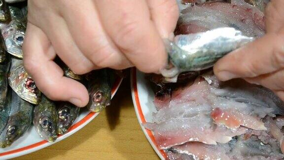 特写俯视图女性的手清洁新鲜的沙丁鱼鱼片