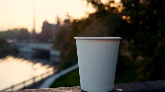 在日落时分一杯咖啡或一杯茶带着蒸汽俯瞰城市景观