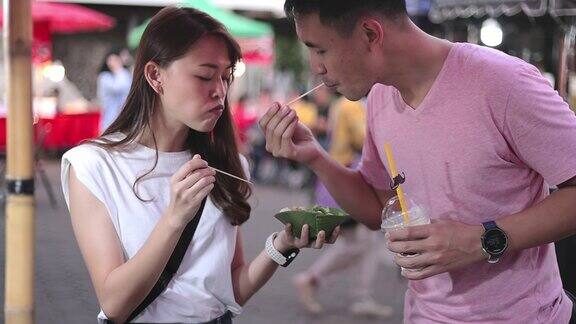 SLOMO一对年轻的亚洲夫妇在街头食品市场购物