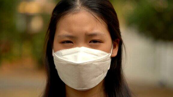 4KCU亚洲女性戴着空气污染口罩看着摄像机