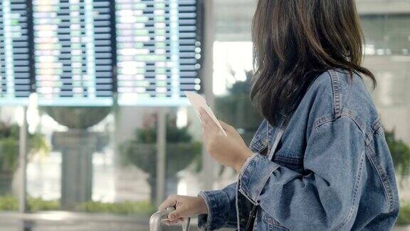 一位女士在机场看登机牌