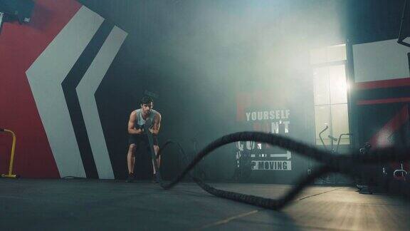 强壮的男人在健身房里用绳子锻炼