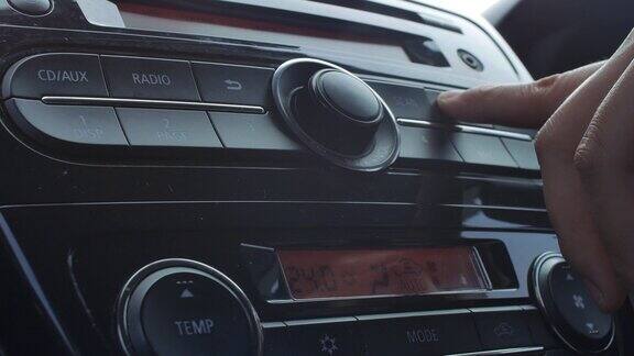 驾驶手按下汽车收音机上的按钮