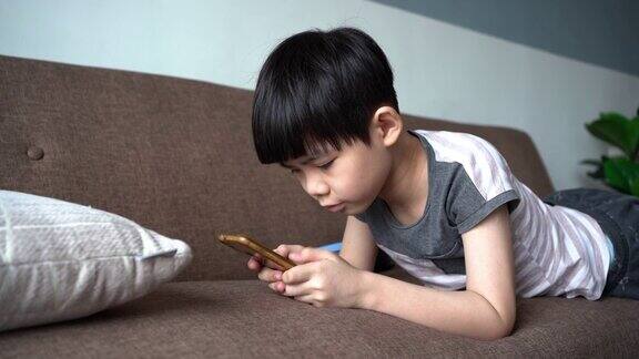 小男孩在沙发上玩手机游戏