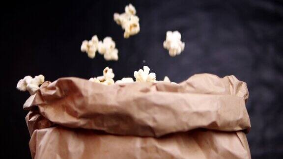 新鲜的爆米花在慢镜头中落入纸袋