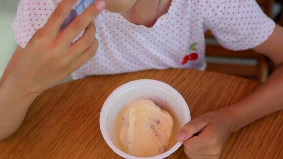 小女孩在街头咖啡馆吃冰淇淋