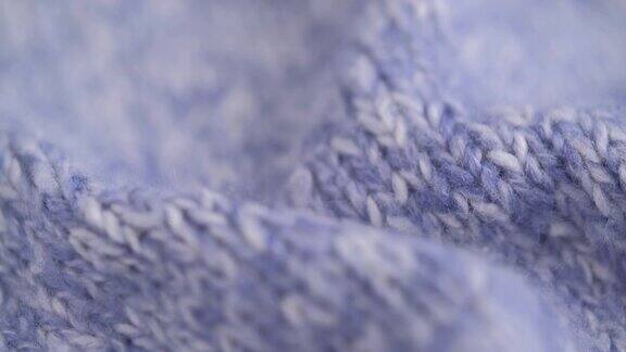 特写旋转皱巴巴的针织羊毛浅蓝色蓬松织物纹理细致微距拍摄