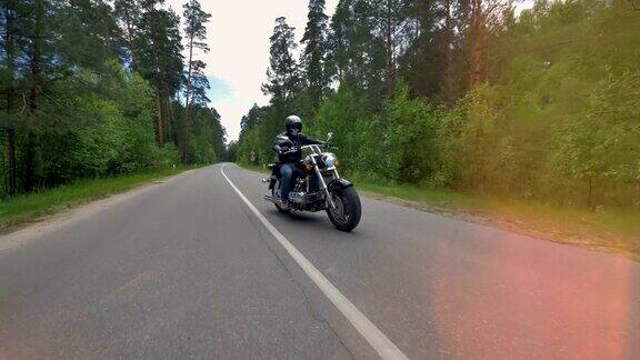 森林里的空旷道路上骑着摩托车