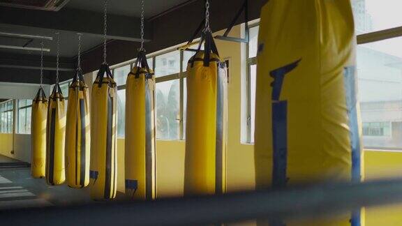 健身房健身俱乐部窗户旁有一排黄色沙袋沙袋是白天的时间