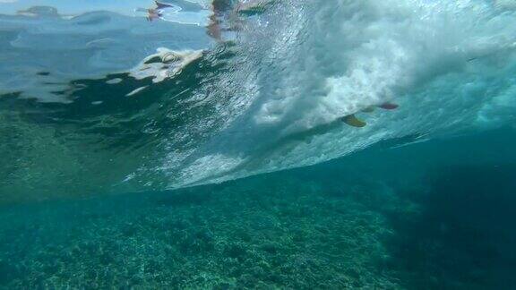 慢动作水下:酷冲浪女孩骑在阳光明媚的斐济大桶波
