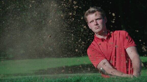 一个高尔夫球手在沙坑里用慢动作打出一记爆发球
