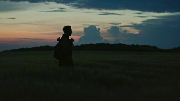 孤独士兵的剪影在红色的夕阳背景下走在田野上这是一个关于二战和冷战时期士兵历史的悲惨概念场景