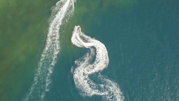 人们乘坐水上摩托艇在蓝色的海洋鸟瞰无人机拍摄人们在开阔水域驾驶水上摩托艇暑假水上运动水上运动赛车运动