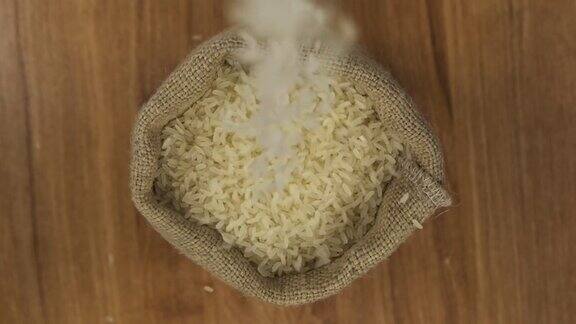 缓慢的运动米粒落入一个打开的袋子里前视图