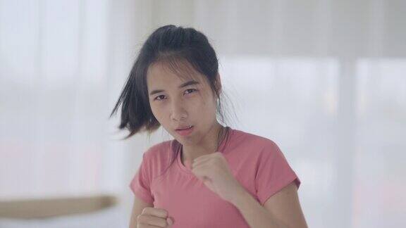 年轻女子在卧室里练拳击
