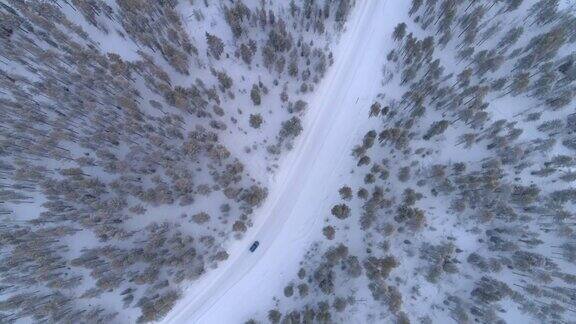 空中俯瞰:汽车在冬日仙境的雪道上行驶