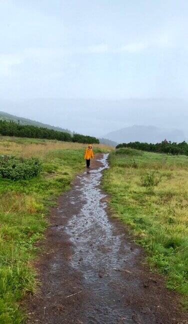 第一人称走在湿山尾女人在黄色雨衣前面