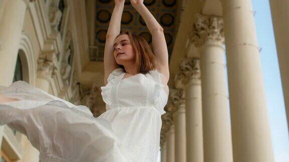 身穿白色礼服的年轻舞者在剧院的楼梯上慢动作跳舞芭蕾舞女演员在户外跳舞4k120fpsProresHQ