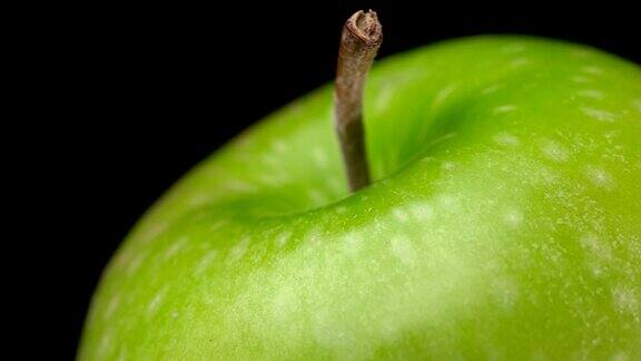美丽的绿色苹果在黑色背景上旋转特写