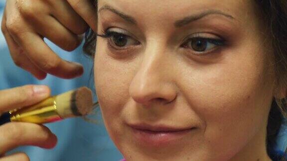 化妆师给年轻女子的眼睛化妆专业化妆师为新娘化妆除草