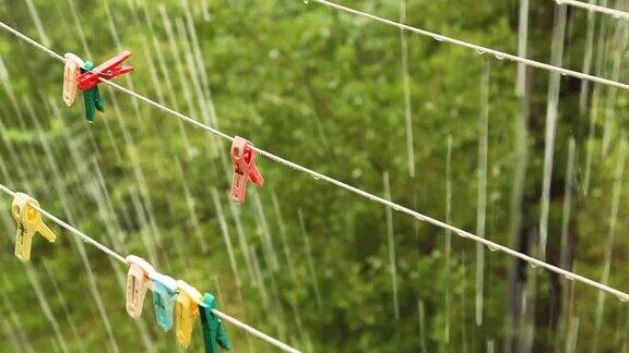 大雨下挂着带彩色别针的晾衣绳