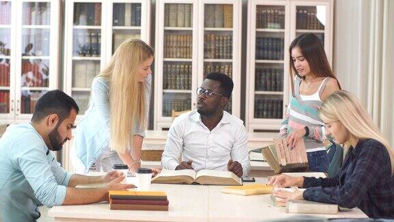 不同种族的学生休闲时间在图书馆与大旧书