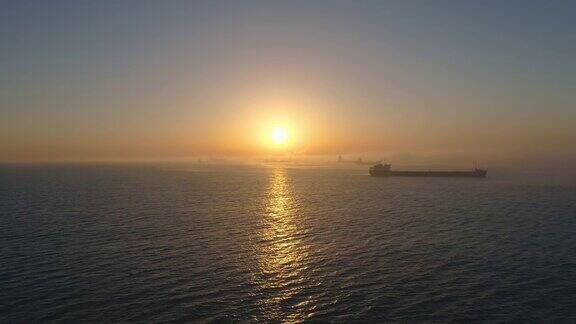 货船在开阔的海面上航行美丽的日出无人机视频4K
