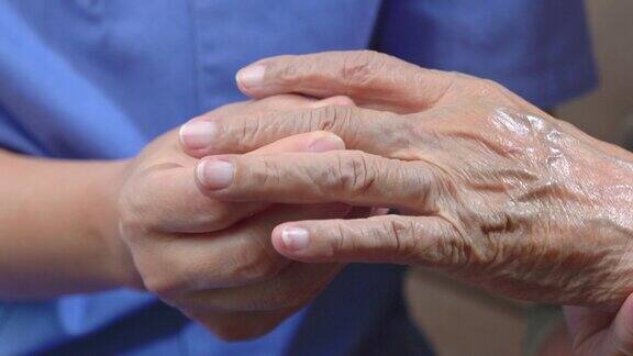 护理人员按摩痛风疼痛肿胀的老年妇女的手指