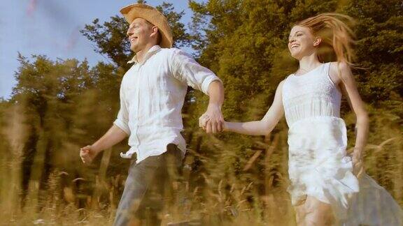 SLOMOTS快乐的夫妇在阳光下跑过草地