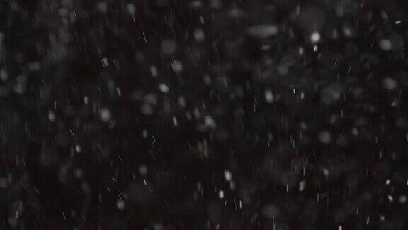 美丽真实的雪花孤立在黑色背景4K用长焦镜头拍摄完美的散景无分级的镜头合成运动图形大的和小的雪雪花孤立的雪花