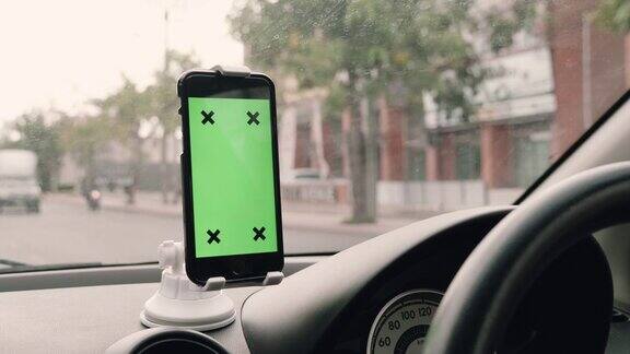司机在车里使用绿色屏幕的智能手机色度键