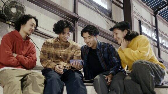 一群日本男孩在智能手机上看视频(慢镜头)