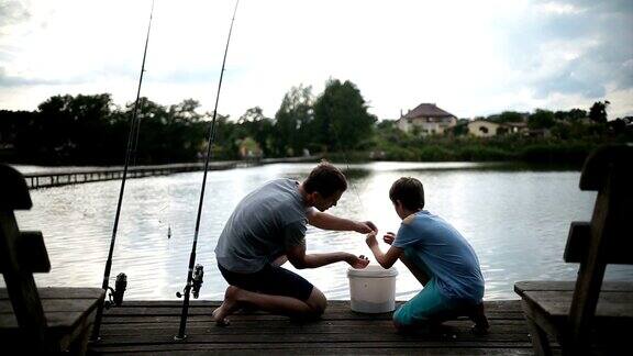 无忧无虑的爸爸和儿子准备在湖上钓鱼