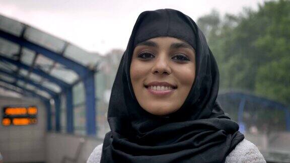 年轻梦想的穆斯林妇女戴着头巾微笑在火车站宗教观念城市观念