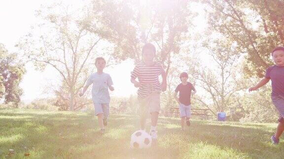 一群男孩和朋友在公园里踢足球慢镜头拍摄