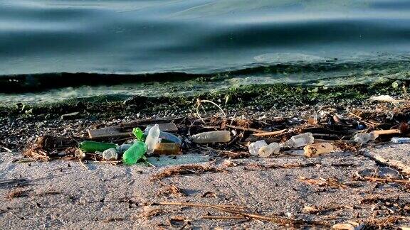 海滩上的垃圾和被污染的绿色污水