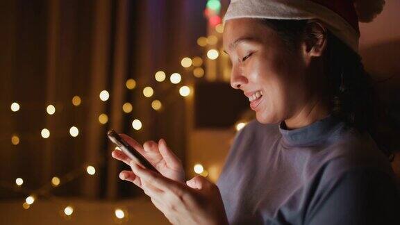 亚洲女人在圣诞节晚上使用智能手机