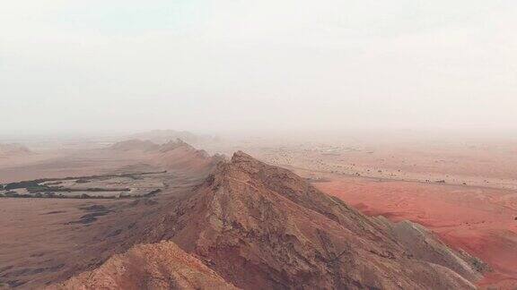 4K无人机镜头鸟瞰梅里哈沙漠的化石岩石与沙波阿拉伯联合酋长国沙丘沙漠的地质景观无人机视频