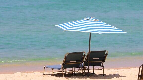 海边的沙滩上有椅子和雨伞