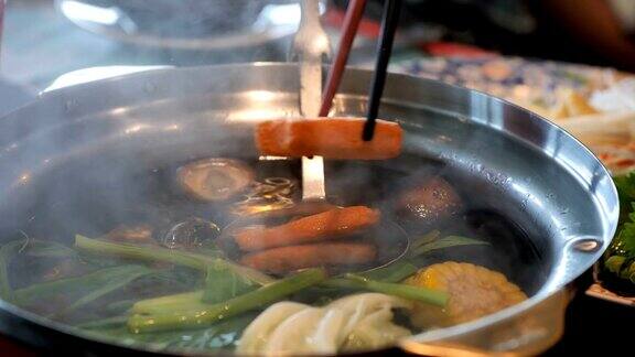 在电锅中煮Suki或Shabu与萝卜牵牛花猪排鱿鱼玉米粉丝和猪肉视频慢动作