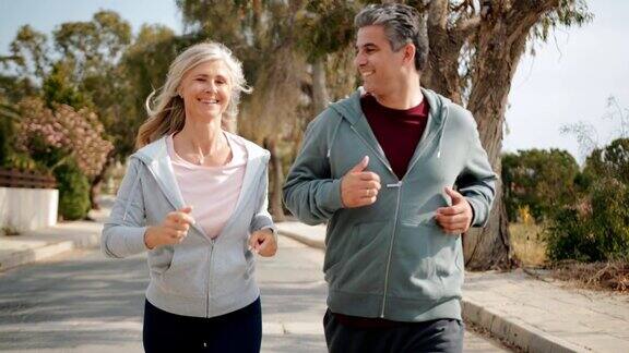 快乐成熟的夫妇一起慢跑在阳光明媚的春天